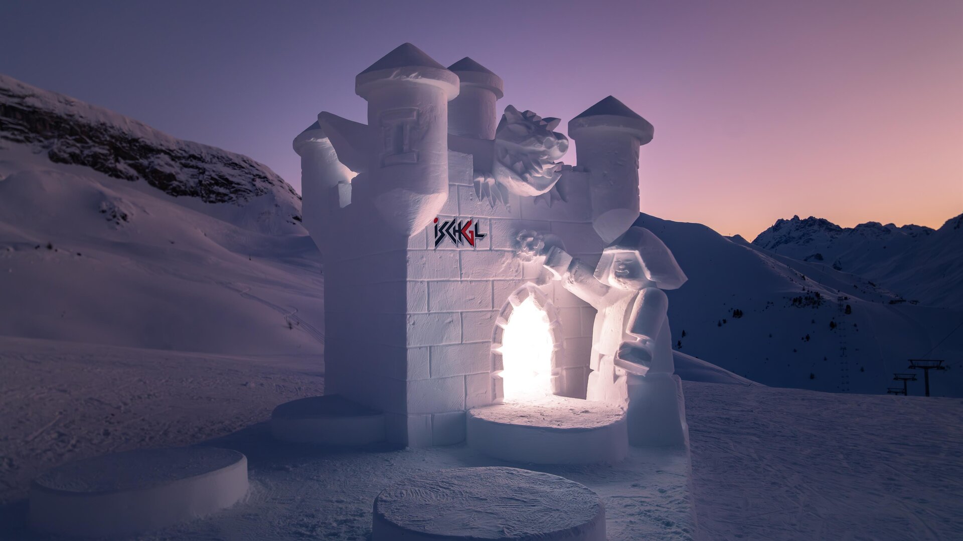 An impressive snow castle masterpiece in a snowy landscape. The castle glows gently in the twilight.