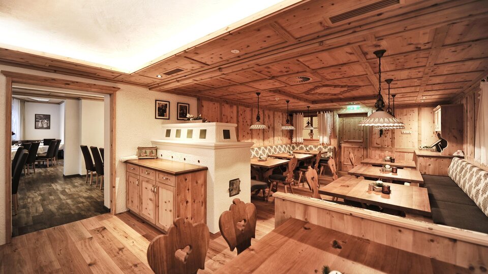 A cozy restaurant with wooden furnishings and warm lighting. The walls and ceilings are made of wood, creating an inviting atmosphere.