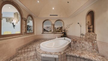 Ein elegantes Badezimmer mit einer modernen Badewanne und verzierten Wänden. Die Gestaltung schafft eine entspannende Atmosphäre.