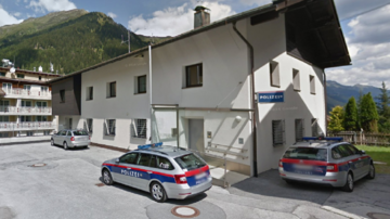 Ein Polizeigebäude in den Bergen mit mehreren Polizeiwagen davor. Die Umgebung ist grün und hügelig. | © Google Maps